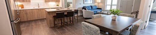 a kitchen and living room with a wooden table and chairs