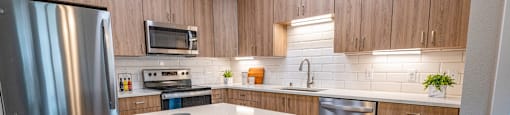 a kitchen with stainless steel appliances and a marble counter top