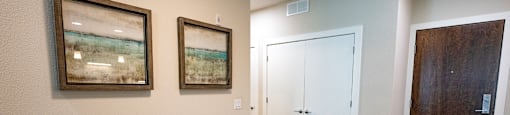 a dining room with a table and chairs and two pictures on the wall