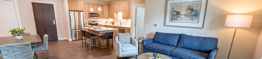a living room and kitchen with a couch and a table