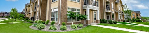 a row of townhomes with green grass and a blue sky