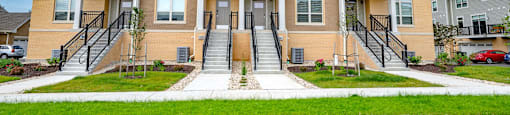 a row of three story houses on a street with grass