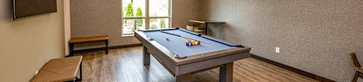 a game room with a pool table and chairs