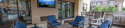 a patio with couches and chairs and a tv