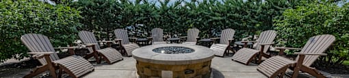 an outdoor patio with chairs and a fire pit