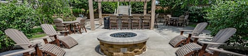 a patio with chairs and a fire pit