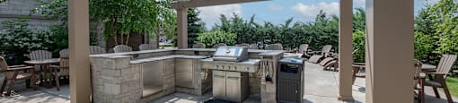 a patio with a grill and a pergola