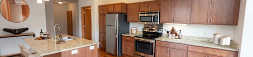 a kitchen and dining area with wooden cabinets and stainless steel appliances