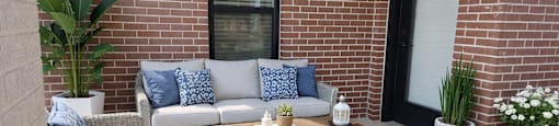 A patio with a sofa, two chairs, and a coffee table.