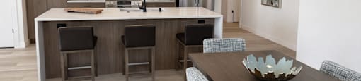 A modern kitchen with a wooden island and bar stools.