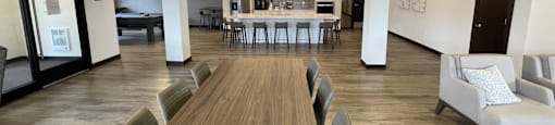 a large room with a table and chairs and a kitchen