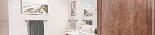 a bathroom with white walls and wood flooring