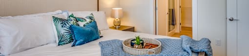 a bedroom with a large bed with pillows and a basket on it