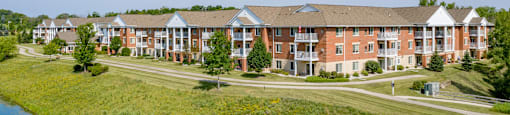 A large building complex with a pond in front.