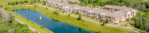 A large building complex with a lake in front.