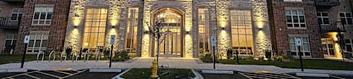 an exterior view of a building at night with lights on it