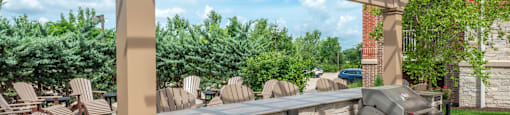 a large outdoor patio with a grill and a table with chairs