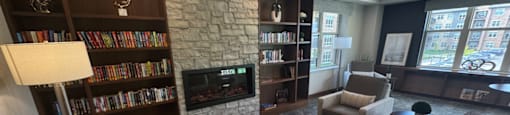 A living room with a stone fireplace and leather couches.