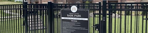 A sign in front of a building entrance reads Bark Park.
