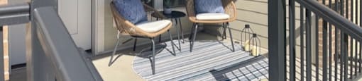 a porch with two chairs and a white door