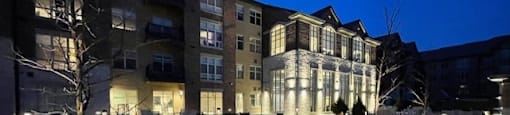 A building with a lit up walkway in front of it.