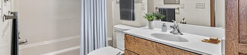 A bathroom with a white toilet, a sink, and a shower.