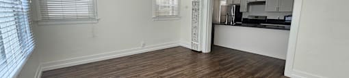 A room with a ceiling fan and wooden flooring.