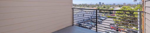 A balcony with a metal railing and a wall with a light switch.