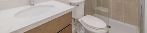 A bathroom with a sink, toilet, and shower.