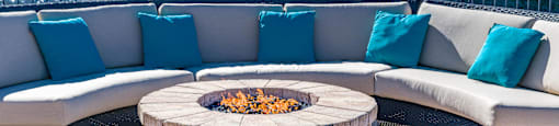 an outdoor seating area with a fire pit and a fountain