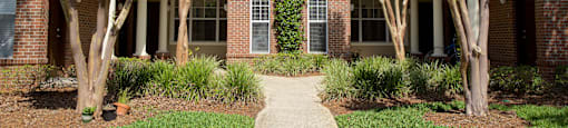 a pathway in front of a house with trees