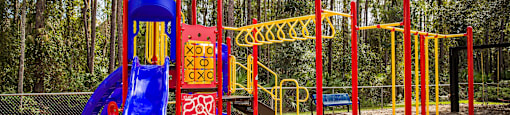 a playground with a blue slide and red monkey bars