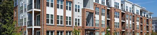 a row of brick and white apartment buildings on a sunny day