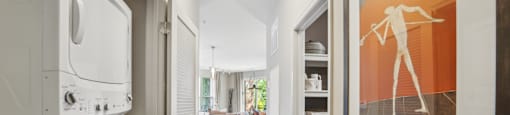a laundry room with a washer and dryer and a hallway to a kitchen