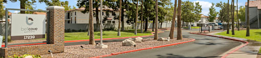 a street with a sign and trees on the side of the road