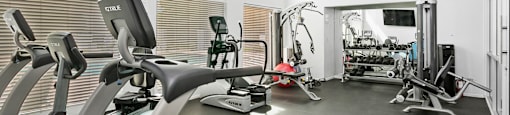 A modern gym with a treadmill, elliptical machines, and other exercise equipment.