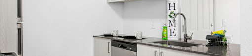 A kitchen with white cabinets and a black stove top.