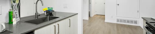 A kitchen with white cabinets and a black dishwasher.