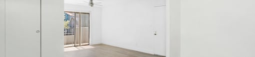 an empty living room with white walls and wood flooring