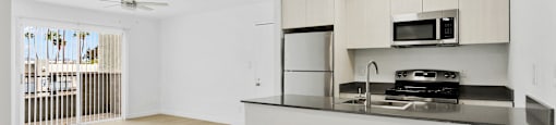 A kitchen with a refrigerator, stove, and microwave.