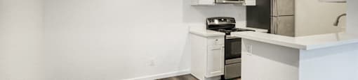 updated kitchen with white cabinets and stainless steel appliances