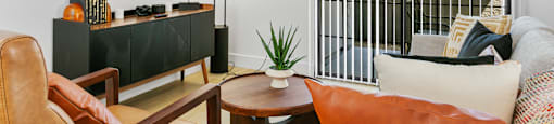 A living room with a brown leather chair, a wooden coffee table, and a white sofa.