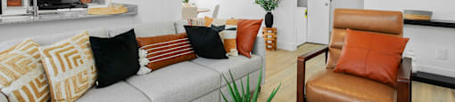 A living room with a grey couch and a brown chair.