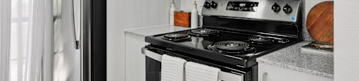 A modern kitchen with a black stove top oven and white cabinets.