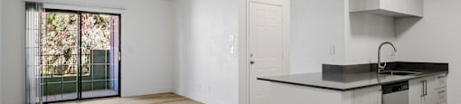 A kitchen with a white counter and wooden floors.