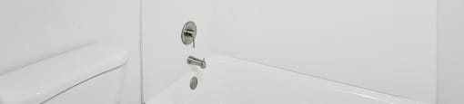 A white bathroom with a toilet, sink, and bathtub.