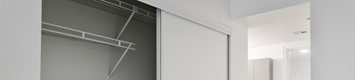 A white closet with a white door is open.