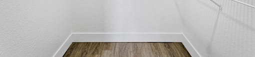 Empty white shelves in a room with wooden floor.