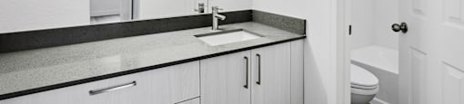 A white bathroom with a sink and toilet.