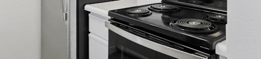 A black refrigerator and a black microwave in a kitchen.